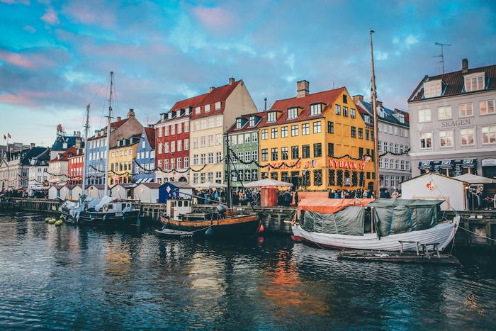 Colourful houses and old boats along Nyhavn in Copenhagen at dusk
