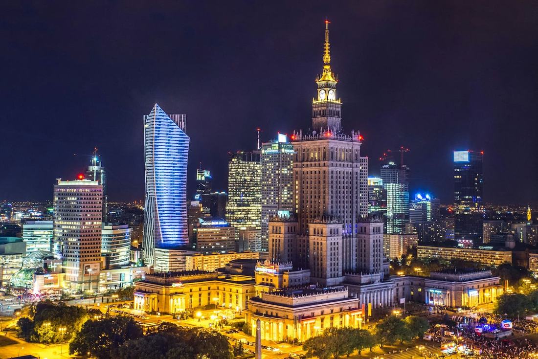 Warsaw's skyline at night with the Palace of Culture and Science and the curved glass Złota 44 tower